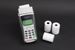 Thermal receipt rolls beside a card payment terminal