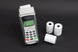 Thermal receipt rolls beside a card payment terminal